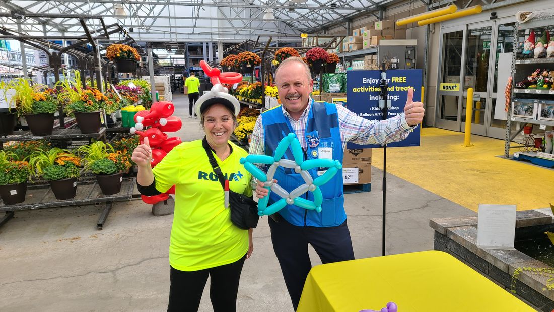 Staff holding balloon creations at a RONA store activation