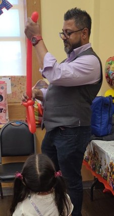 Balloon artist twisting a balloon sculpture at a birthday party